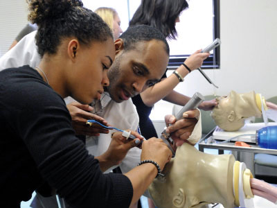 A student trains with an NYLF Medicine advisor using the same medical equipment and facilities that graduate students and professionals do