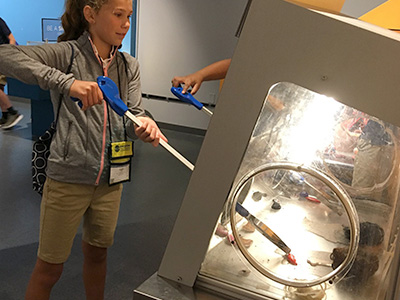 A student interacting with a hands-on, off-site exhibit during NYLF Pathways to STEM Alumni
