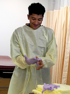 A student dons protective equipment during GW Careers in Health Care