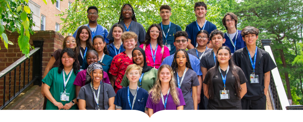 Group of medical professionals posing for picture on stairs outside