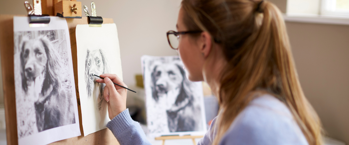 girl sketching a picture of a dog