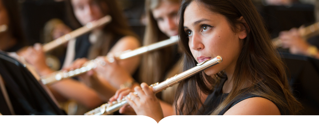 Student playing the flute in an orchestra